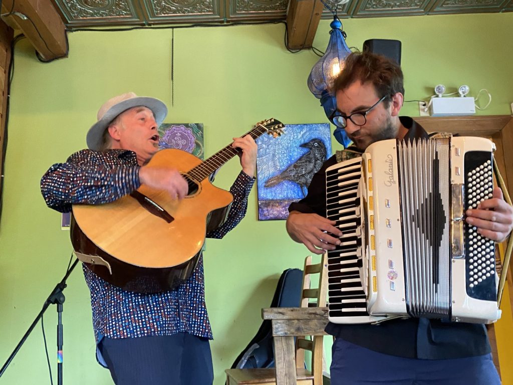 Un joueur de guitare et un joueur d'accordéon interprétent une chanson entrainante
